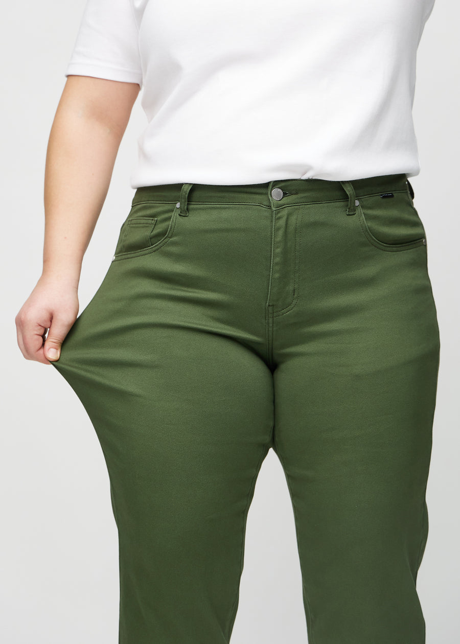 Regular-Jeans für Damen in Dunkelgrün, Farbe Renewals. Ein Plus-Size-Model dehnt den Stoff am Oberschenkel, um den Stretch zu zeigen.