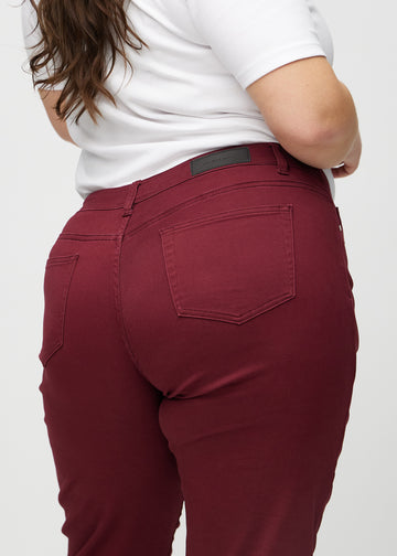 Regular-Jeans für Damen in Dunkelrot, Farbe Santas. Nahaufnahme von hinten an einem Plus-Size-Model, um Passform und Details zu zeigen.