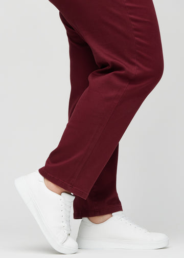 Regular-Jeans für Damen in Dunkelrot, Farbe Santas. Nahaufnahme an den Knöcheln eines Plus-Size-Models, um den geraden Beinabschluss zu zeigen.