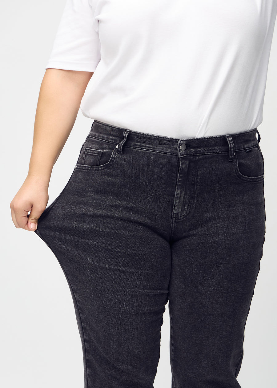 Regular-Jeans für Damen in Dunkelgrau, Farbe Shadows. Ein Plus-Size-Model dehnt den Stoff am Oberschenkel, um den Stretch zu zeigen.