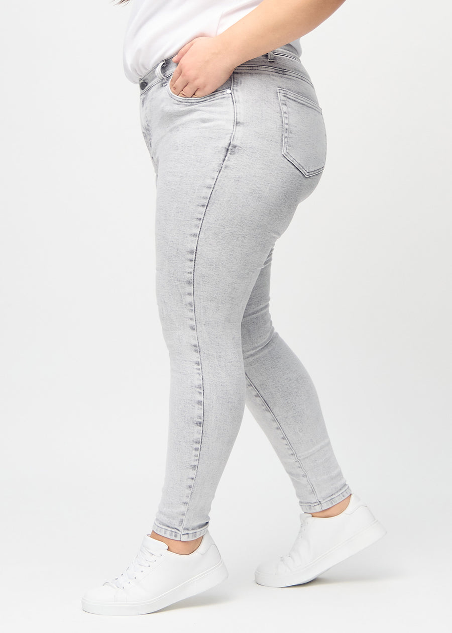 Skinny-Jeans für Damen in Hellgrau, Farbe Ashes. Seitenansicht an einem Plus-Size-Model.