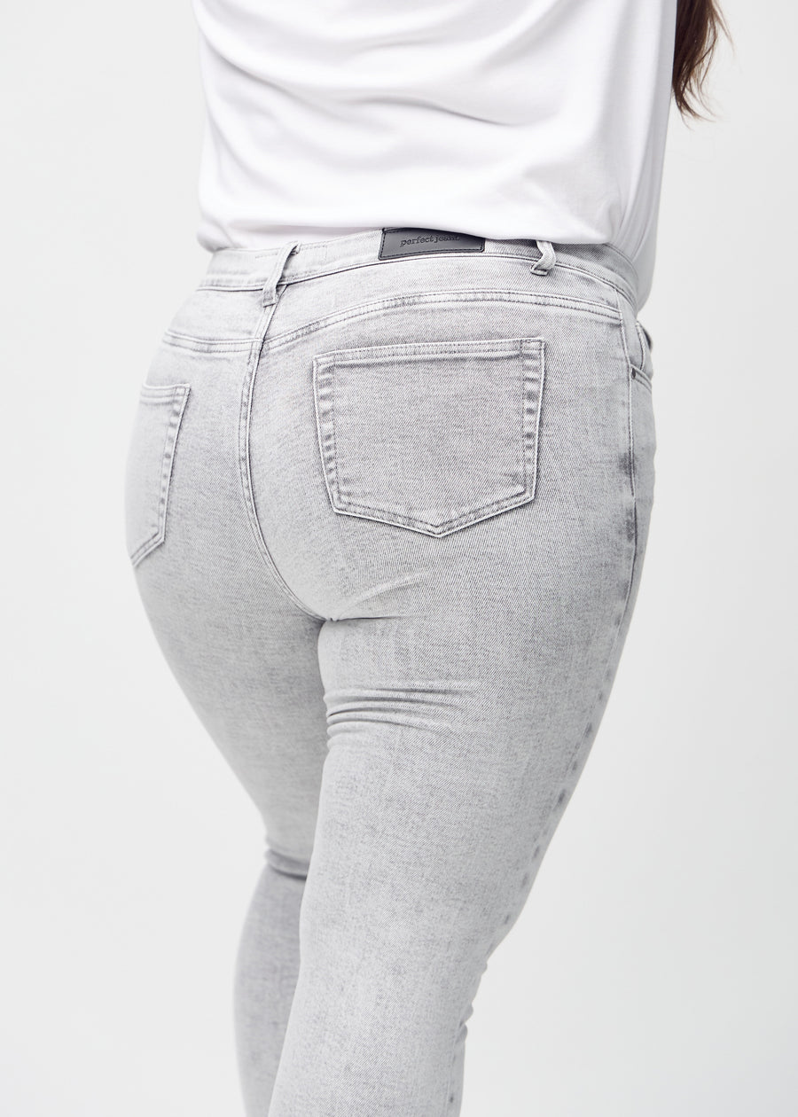 Skinny-Jeans für Damen in Hellgrau, Farbe Ashes. Nahaufnahme der Rückseite an einem Plus-Size-Model, um Details zu zeigen.