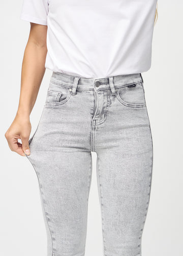 Skinny-Jeans für Damen in Hellgrau, Farbe Ashes. Ein Model dehnt den Jeansstoff am Oberschenkel, um den Stretch zu zeigen.