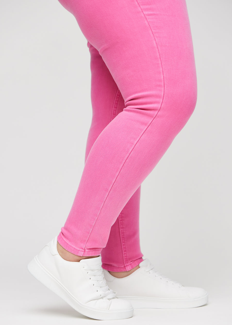 Skinny-Jeans für Damen in Hellrosa, Farbe Flamingos. Nahaufnahme der eng anliegenden Beinabschlüsse am Knöchel eines Plus-Size-Models.