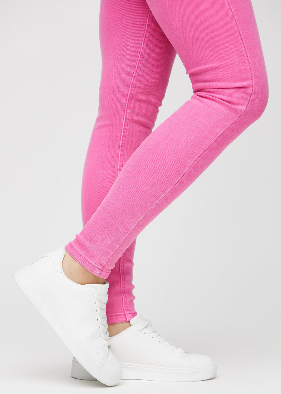 Skinny-Jeans für Damen in Hellrosa, Farbe Flamingos. Nahaufnahme der eng anliegenden Beinabschlüsse am Knöchel eines Models.