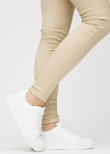 Skinny-Jeans für Damen in Beige, Farbe Gazelles. Nahaufnahme am Knöchel eines Models, die eng anliegenden Beinabschlüsse sind zu sehen.