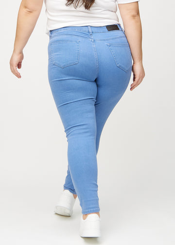 Skinny-Jeans für Damen in Blau, Farbe Geraniums. Rückansicht an einem Plus-Size-Model, die gesamte Passform ist zu sehen.