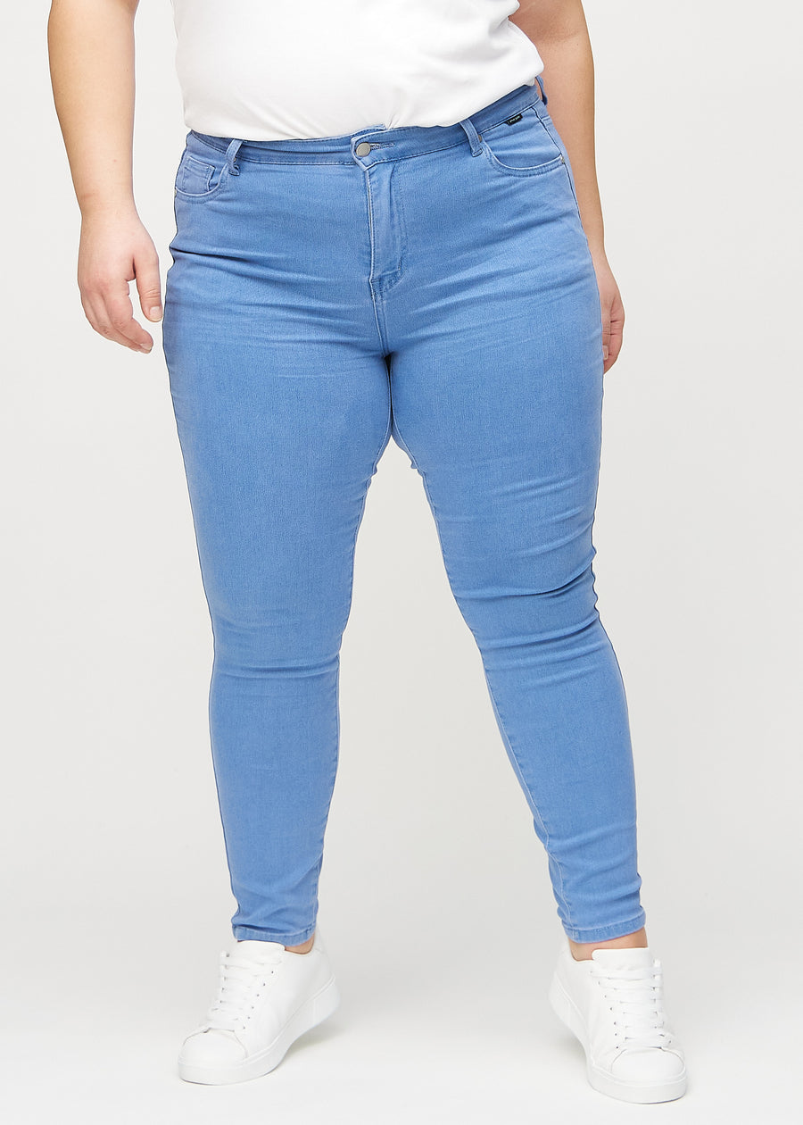 Skinny-Jeans für Damen in Blau, Farbe Geraniums. Vorderansicht an einem Plus-Size-Model; die Jeans liegen eng am Bein an.