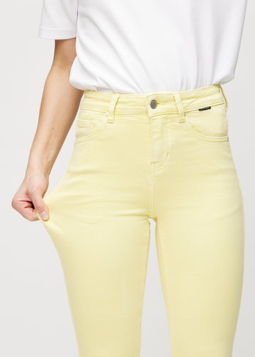 Skinny-Jeans für Damen in Hellgelb, Farbe Lemonades. Ein Model dehnt den Jeansstoff am Oberschenkel, um den Stretch zu zeigen.