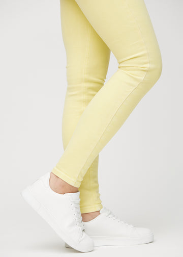 Skinny-Jeans für Damen in Hellgelb, Farbe Lemonades. Nahaufnahme der eng anliegenden Beinabschlüsse am Knöchel eines Models.