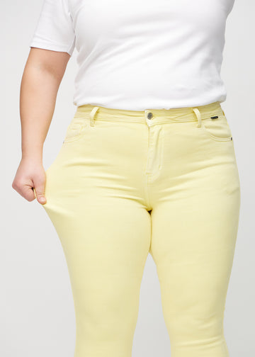 Skinny-Jeans für Damen in Hellgelb, Farbe Lemonades. Ein Plus-Size-Model dehnt den Jeansstoff am Oberschenkel, um den Stretch zu zeigen.