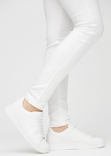 Skinny-Jeans für Damen in Weiß, Farbe Marguerites. Nahaufnahme der eng anliegenden Beinabschlüsse am Knöchel eines Models.