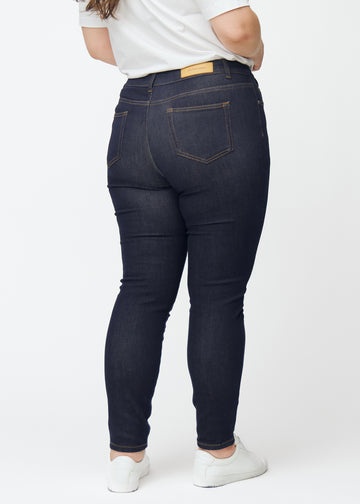 Tief dunkelblaue Denim jeans für Damen in der Farbe Midnights von hinten an einem Plus-Size-Model gesehen.