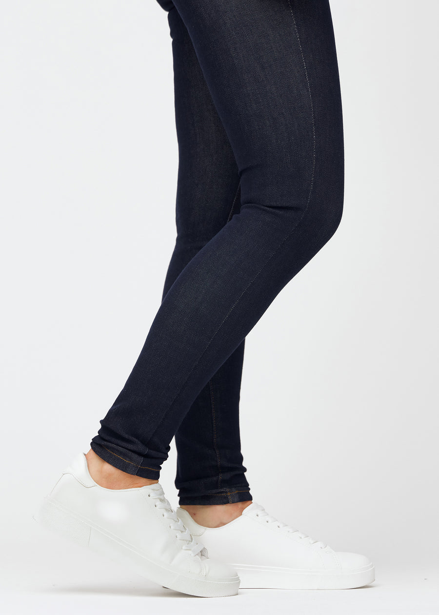 Tief dunkelblaue Denim jeans für Damen in der Farbe Midnights mit skinny Passform in Nahaufnahme an den Knöcheln, um den eng anliegenden Abschluss zu zeigen.