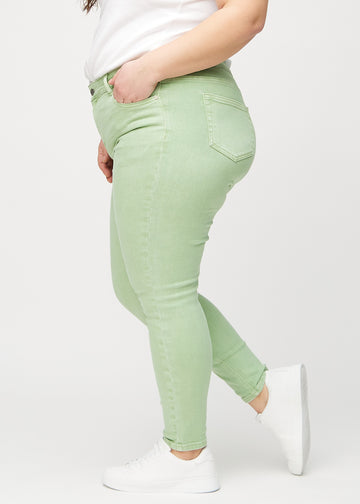Hellgrüne skinny jeans von der Seite an einem Plus-Size-Model gesehen.
