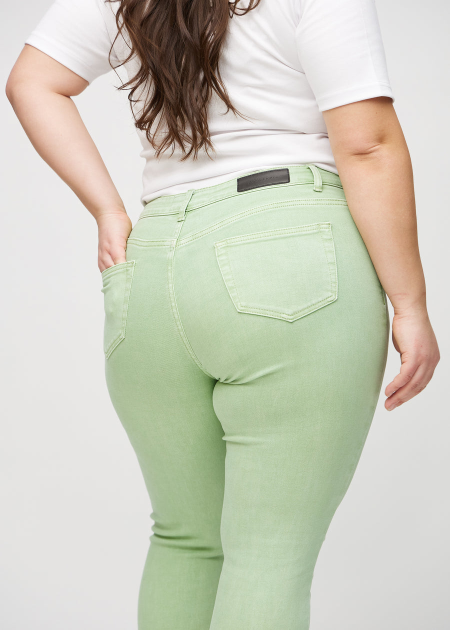 Hellgrüne skinny jeans von hinten in Nahaufnahme an einem Plus-Size-Model, um Details zu zeigen.