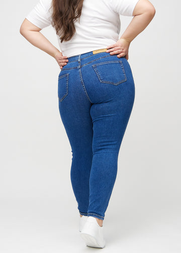 Skinny-Jeans für Damen in Dunkelblau, Farbe Oceans. Rückansicht an einem Plus-Size-Model mit der gesamten Passform.
