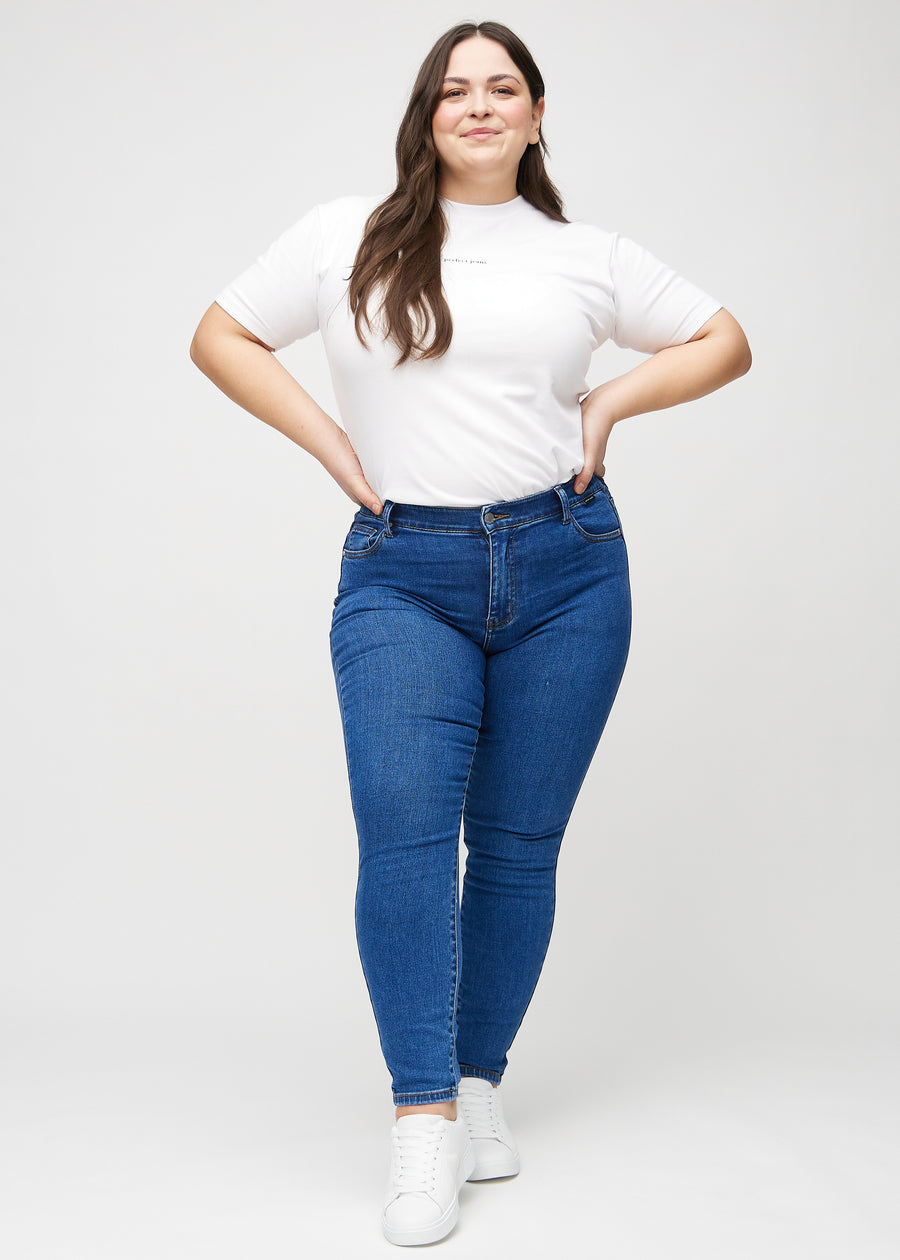 Skinny-Jeans für Damen in Dunkelblau, Farbe Oceans. Ganzkörperansicht eines Plus-Size-Models in den Jeans.
