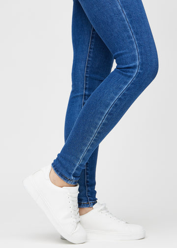 Skinny-Jeans für Damen in Dunkelblau, Farbe Oceans. Nahaufnahme der eng anliegenden Beinabschlüsse am Knöchel eines Models.