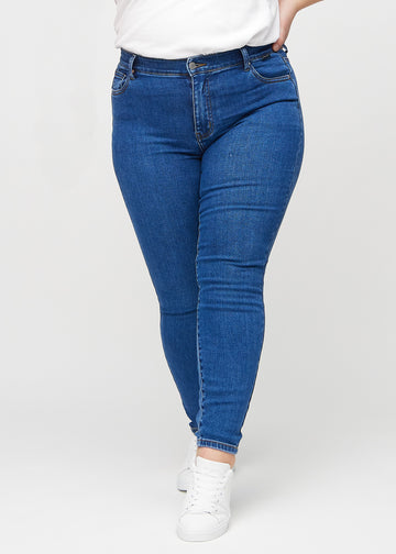 Skinny-Jeans für Damen in Dunkelblau, Farbe Oceans. Vorderansicht an einem Plus-Size-Model, mit eng anliegenden Beinen.