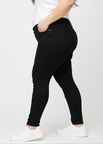 Skinny-Jeans für Damen in Schwarz, Farbe Ravens. Seitenansicht an einem Plus-Size-Model.