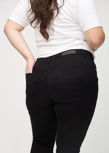 Skinny-Jeans für Damen in Schwarz, Farbe Ravens. Detailansicht der Rückseite an einem Plus-Size-Model.