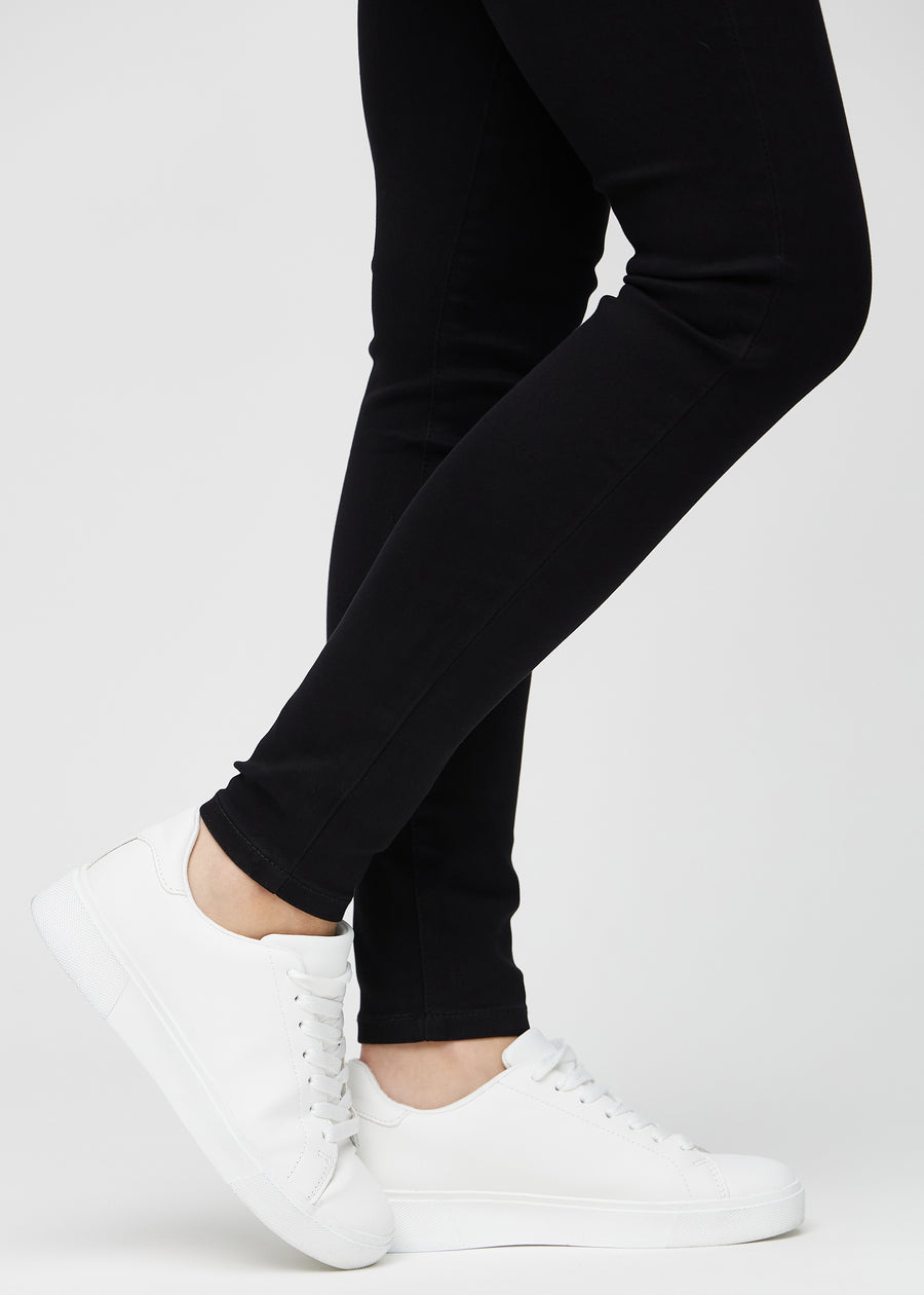 Die Knöchel eines Models, sodass man sehen kann, wie eng die Jeans in einer Skinny Passform sitzen.