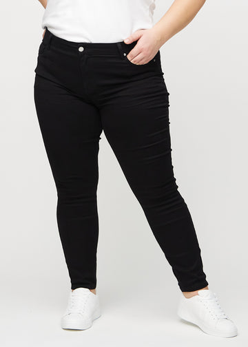 Skinny-Jeans für Damen in Schwarz, Farbe Ravens. Vorderansicht an einem Plus-Size-Model; die Jeans liegen eng am Bein an.