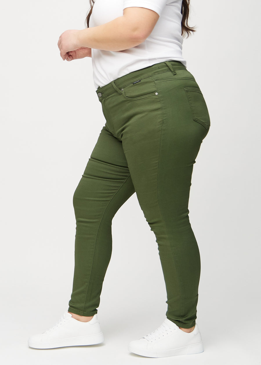 Dunkelgrüne skinny jeans von der Seite an einem Plus-Size-Model gesehen.
