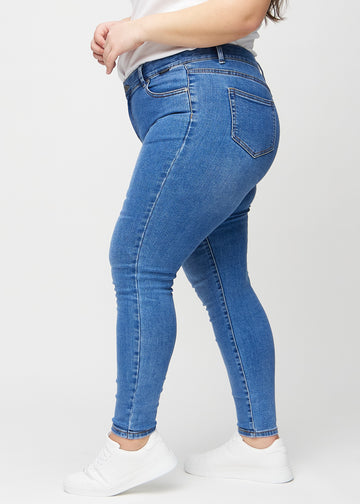 Denim skinny jeans von der Seite an einem Plus-Size-Model gesehen.