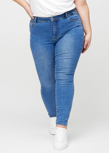 Denim skinny jeans, Modellname Rivers, das bei einem Plus-Size-Model eng am Bein anliegt, von vorne gesehen.