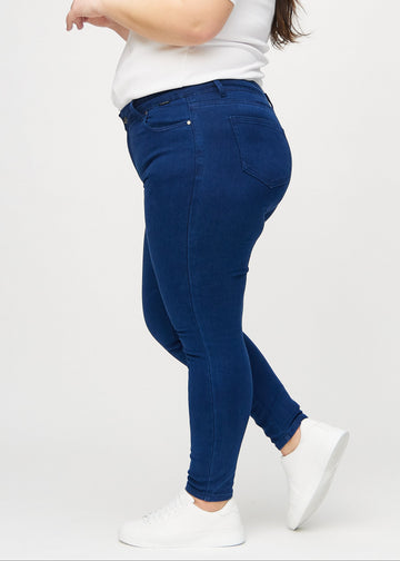 Skinny-Jeans für Damen in Dunkelblau, Farbe Royals. Seitenansicht an einem Plus-Size-Model.