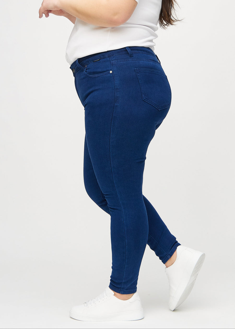 Skinny-Jeans für Damen in Dunkelblau, Farbe Royals. Seitenansicht an einem Plus-Size-Model.