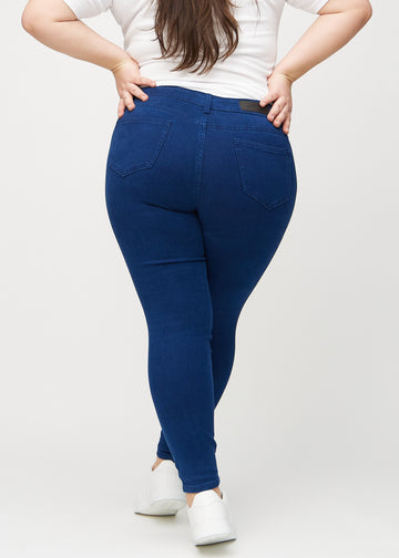 Skinny-Jeans für Damen in Dunkelblau, Farbe Royals. Rückansicht an einem Plus-Size-Model, die gesamte Passform ist zu sehen.