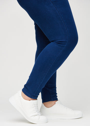 Skinny-Jeans für Damen in Dunkelblau, Farbe Royals. Nahaufnahme am Knöchel eines Plus-Size-Models, die eng anliegenden Beinabschlüsse sind zu sehen.