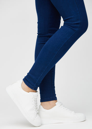 Skinny-Jeans für Damen in Dunkelblau, Farbe Royals. Nahaufnahme am Knöchel eines Models, die eng anliegenden Beinabschlüsse sind zu sehen.