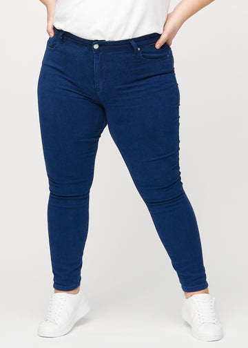 Skinny-Jeans für Damen in Dunkelblau, Farbe Royals. Vorderansicht an einem Plus-Size-Model; die Jeans liegen eng am Bein an.