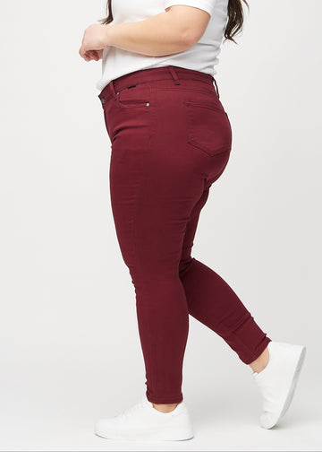 Skinny-Jeans für Damen in Dunkelrot, Farbe Santas. Seitenansicht an einem Plus-Size-Model.