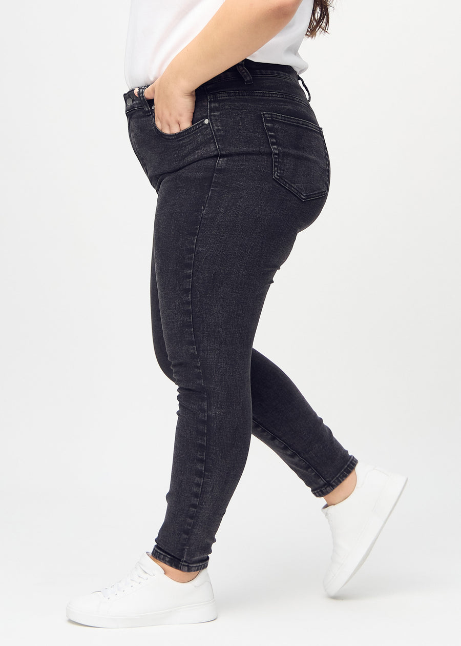 Skinny-Jeans für Damen in Dunkelgrau, Farbe Shadows. Seitenansicht an einem Plus-Size-Model.