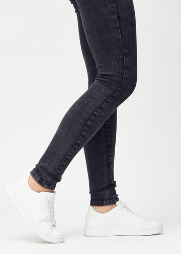 Skinny-Jeans für Damen in Dunkelgrau, Farbe Shadows. Nahaufnahme der eng anliegenden Beinabschlüsse am Knöchel eines Models.