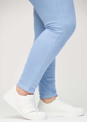 Skinny-Jeans für Damen in Hellblau, Farbe Skies. Nahaufnahme am Knöchel eines Plus-Size-Models, die eng anliegenden Beinabschlüsse sind zu sehen.