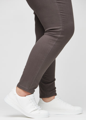 Skinny-Jeans für Damen in Graubraun, Farbe Thunders. Nahaufnahme der eng anliegenden Beinabschlüsse am Knöchel eines Plus-Size-Models.
