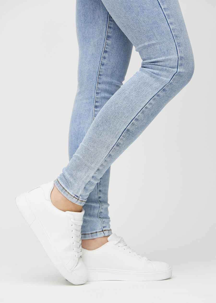 Skinny-Jeans für Damen in Hellblau, Farbe Waves. Nahaufnahme der eng anliegenden Beinabschlüsse am Knöchel eines Models.