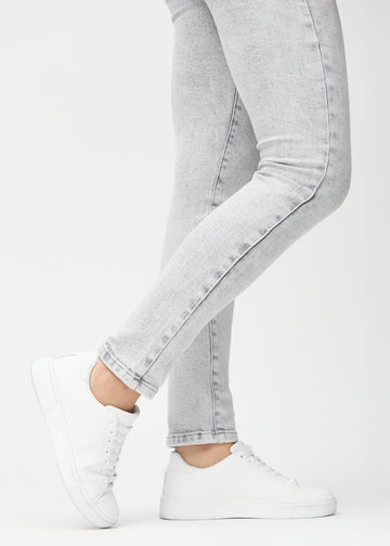 Slim-Jeans für Damen in Hellgrau, Farbe Ashes. Nahaufnahme an den Knöcheln eines Models, um die Passform am Beinabschluss zu zeigen.