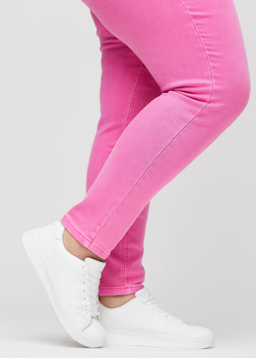 Slim-Jeans für Damen in Hellrosa, Farbe Flamingos. Nahaufnahme an den Knöcheln eines Plus-Size-Models, um die Passform am Beinabschluss zu zeigen.