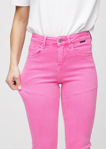 Slim-Jeans für Damen in Hellrosa, Farbe Flamingos. Ein Model zieht am Jeansstoff am Oberschenkel, um den Stretch zu zeigen.