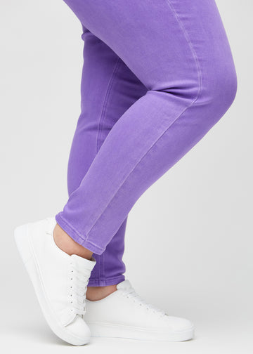 Slim-Jeans für Damen in Lila, Farbe Lavenders. Nahaufnahme an den Knöcheln eines Plus-Size-Models, um die Passform am Beinabschluss zu zeigen.