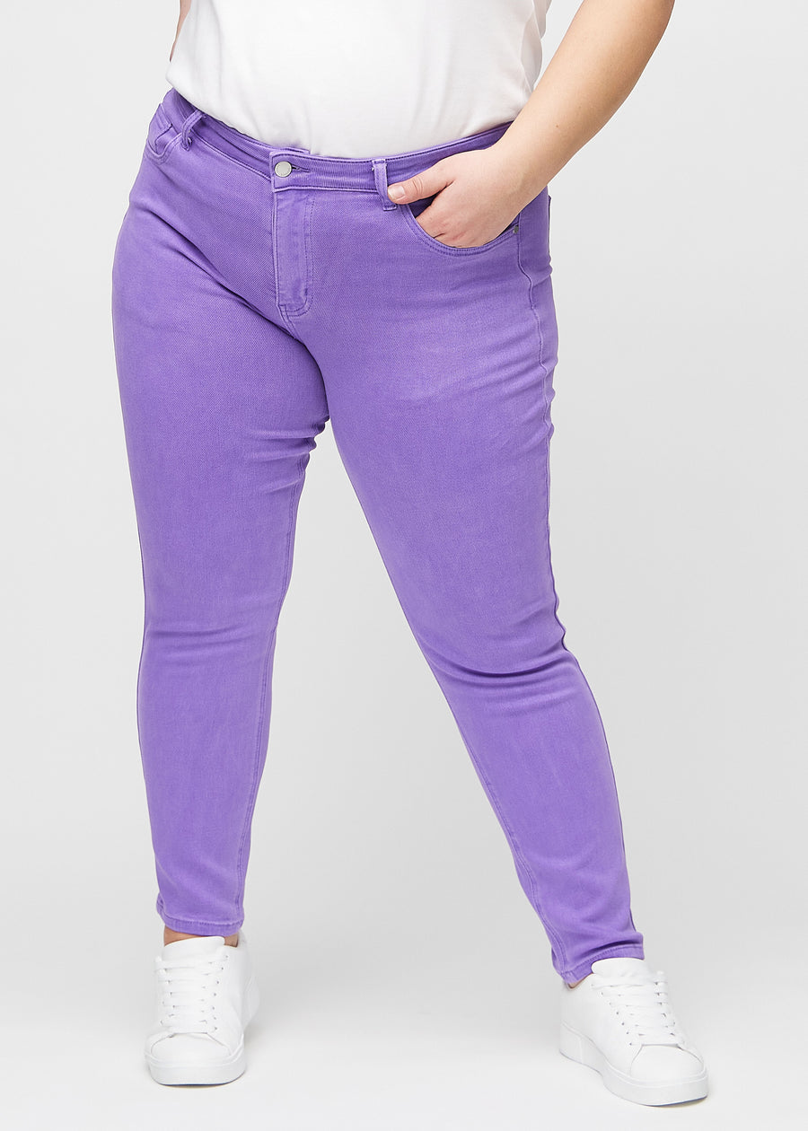 Slim-Jeans für Damen in Lila, Farbe Lavenders. Vorderansicht an einem Plus-Size-Model, körpernah geschnitten mit etwas mehr Platz am Knöchel.