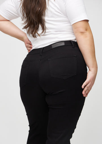 Slim-Jeans für Damen in Schwarz, Farbe Ravens. Nahaufnahme der Rückseite an einem Plus-Size-Model, die Details sind gut erkennbar.