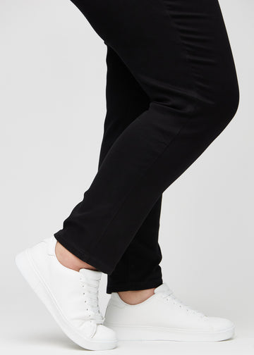 Die Knöchel eines Plus-Size-Models, sodass man sehen kann, wie eng die Jeans in einer Slim Passform anliegen.